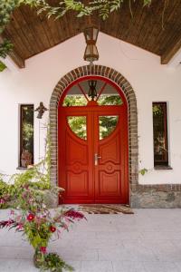 Dom w Starym Parku في Biskupice: باب احمر لبيت بجدار من الطوب