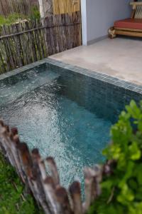 ポルト・デ・ペードラスにあるAlameda Lounge Pousadaの柵の横の庭の水のプール