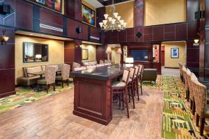 a large room with a bar with chairs and a television at Hampton Inn & Suites Austin South Buda in Buda