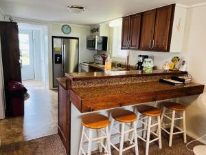a kitchen with a counter with stools around it at Hidden Treasure in Holden Beach