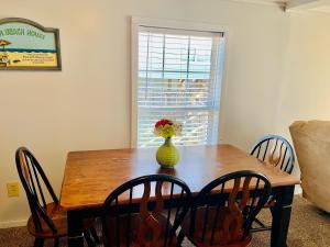 a dining room table with a vase of flowers on it at Hidden Treasure in Holden Beach