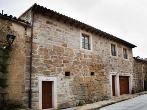 un antiguo edificio de piedra con dos puertas. en La Casa del Vino, en Fermoselle