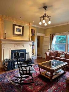 a living room with a chair and a table and a fireplace at Historical Home, near wineries, weddings & shops in Snohomish