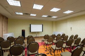 einen Konferenzraum mit Stühlen und einem weißen Bildschirm in der Unterkunft Hilton Garden Inn Queens/JFK in Queens
