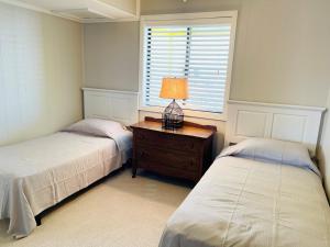 a bedroom with two beds and a table with a lamp at The Skipper condo in Holden Beach +29 photos