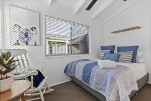 a bedroom with a bed and a table and a window at Pet friendly family escape in Coolum Beach