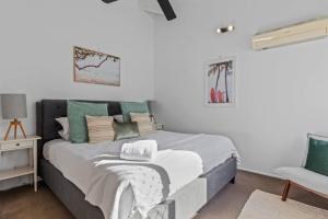 a bedroom with a large bed and a chair at Pet friendly family escape in Coolum Beach