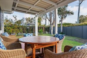 a patio with a wooden table and chairs at Pet friendly family escape in Coolum Beach