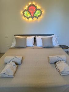 a large bed with three pillows on top of it at Il Gelsomino luxury suites in Bari