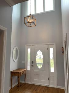 a hallway with a white door with a table and a window at Tortuga home in Holden Beach