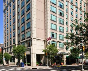 Um edifício alto com uma bandeira americana à frente. em Hampton Inn Philadelphia Center City-Convention Center em Filadélfia