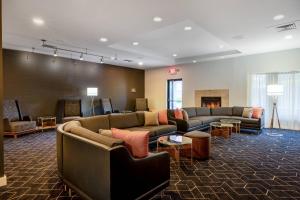 a waiting room with couches and a fireplace at Courtyard Columbus Airport in Columbus