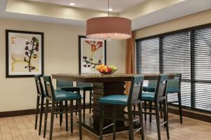a kitchen with a bar with chairs and a table at Hampton Inn Binghamton/Johnson City in Binghamton