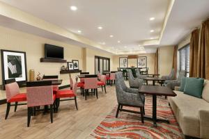 a waiting room with tables and chairs and a couch at Hampton Inn Binghamton/Johnson City in Binghamton