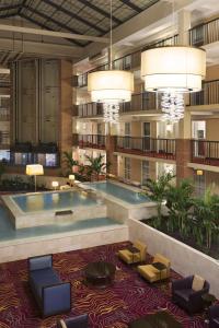 a hotel lobby with a large pool and chairs and lights at Embassy Suites Cleveland - Beachwood in Beachwood