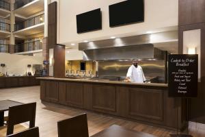 a chef standing behind a counter in a kitchen at Embassy Suites Cleveland - Beachwood in Beachwood