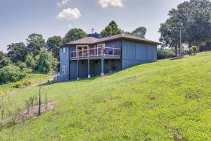 a house on top of a grassy hill at Guntersville Hideaway with Mountain and Lake Views! in Albertville
