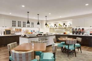 a restaurant with tables and chairs and a kitchen at Homewood Suites by Hilton Dallas-DFW Airport N-Grapevine in Grapevine