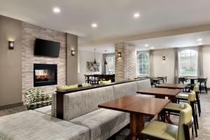 a living room with a couch and tables and a fireplace at Homewood Suites by Hilton Columbus-Dublin in Dublin