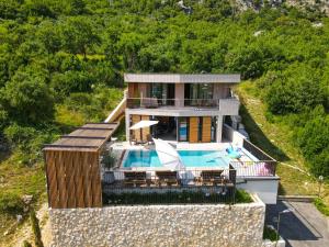 une maison avec une piscine sur une colline dans l'établissement Palazzo Vimbula - Five Star Luxury Villa, à Mokošica