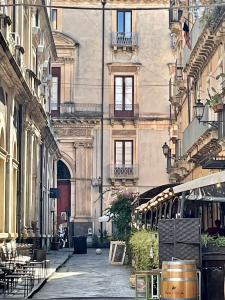 un callejón en una ciudad con mesas y sillas en Sleep Inn Catania rooms - Affittacamere, en Catania