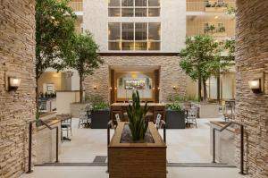 a lobby with tables and chairs in a building at Embassy Suites by Hilton Dallas Market Center in Dallas