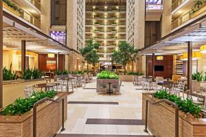 an empty lobby of a hotel with tables and chairs at Embassy Suites by Hilton Dallas Market Center in Dallas