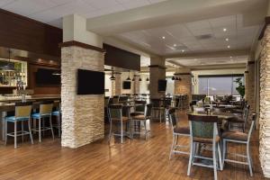 a restaurant with tables and chairs and a bar at Embassy Suites by Hilton Dallas Market Center in Dallas