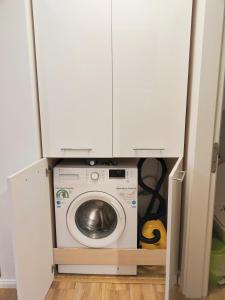 a washing machine in a closet with white cabinets at Baneasa Apartment Residence in Bucharest