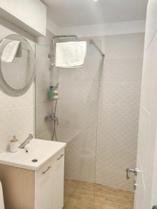 bagno con lavandino e doccia in vetro di Baneasa Apartment Residence a Bucarest