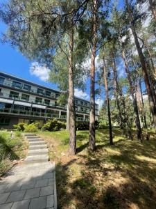 an office building with trees in front of a building at Apartament Navy Blue z tarasem in Serock