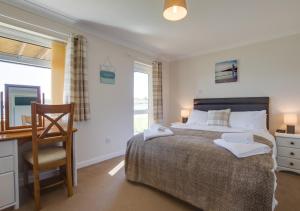 a bedroom with a bed and a desk and a chair at Y Nyth in Y Felinheli