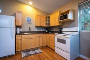 a kitchen with white appliances and wooden cabinets at Upper Mountain Haus Studio Close to Slopes Mtns in Ogden