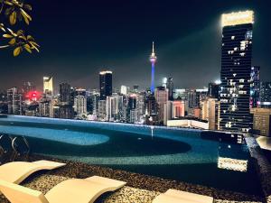 una piscina con vista sullo skyline della città di notte di Axon Serviced Suites Kuala Lumpur a Kuala Lumpur
