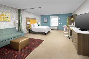朗蒙特Home2 Suites By Hilton Longmont的配有床和沙发的酒店房间