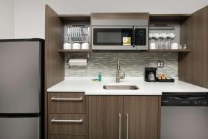 Home2 Suites By Hilton Longmont في لونغمونت: مطبخ مع حوض وميكروويف