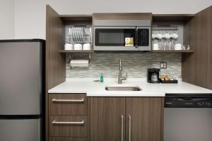 朗蒙特Home2 Suites By Hilton Longmont的配有水槽和微波炉的厨房