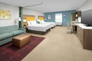 朗蒙特Home2 Suites By Hilton Longmont的配有床和沙发的酒店房间
