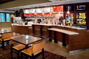 a bar with tables and chairs in a restaurant at Courtyard By Marriott Hartford Windsor Airport in Windsor