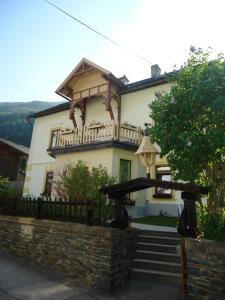 une maison avec un balcon et des escaliers en face de celle-ci dans l'établissement Haus Obernig, à Mallnitz