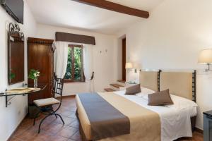 モンテローニ・ダルビアにあるHotel Ristorante Borgo Anticoの大きなベッドとテーブルが備わるホテルルームです。