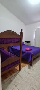 - une chambre dotée d'un lit avec des draps violets dans l'établissement Odelbor Departamento, à Ushuaia