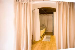 a bathroom with a white shower curtain and a tub at Viscri 125 in Viscri