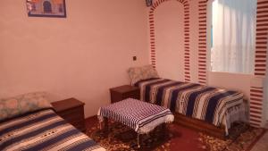 uma sala de estar com duas camas e uma cadeira em Dar Panorama Chefchaouen em Chefchaouene