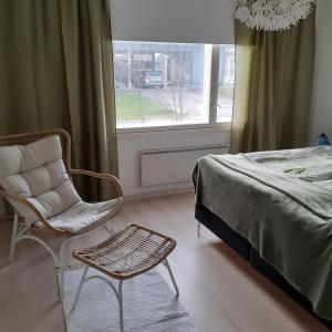 una camera con un letto e una sedia e una finestra di Huone Seesteisessä Mummolassa a Kalajoki