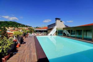 einem Pool an der Seite eines Gebäudes in der Unterkunft Hotel Park in Castiglion Fiorentino