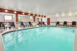 een zwembad in een hotelkamer met tafels en stoelen bij Hampton Inn Sacramento/Rancho Cordova in Rancho Cordova