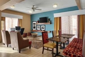 a living room with tables and chairs and a dining room at Hampton Inn Phoenix-Chandler in Chandler