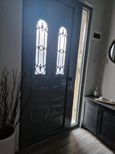 een zwarte deur met twee ramen in een kamer bij Kalipso home in Mytilini