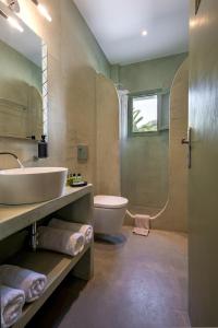 a bathroom with a sink and a tub and a toilet at Ambeli Apartments in Perivolos